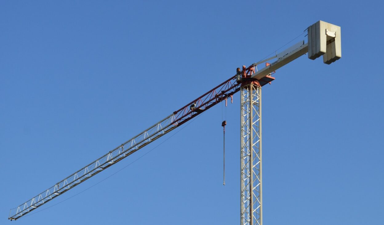 Crane at construction site lifting precast concrete panel